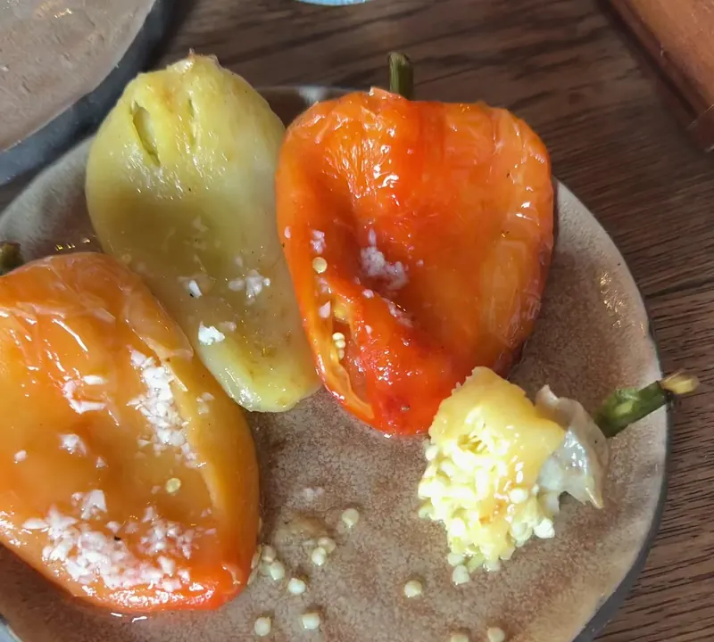 Soft baked red and yellow peppers on a stoneware plate